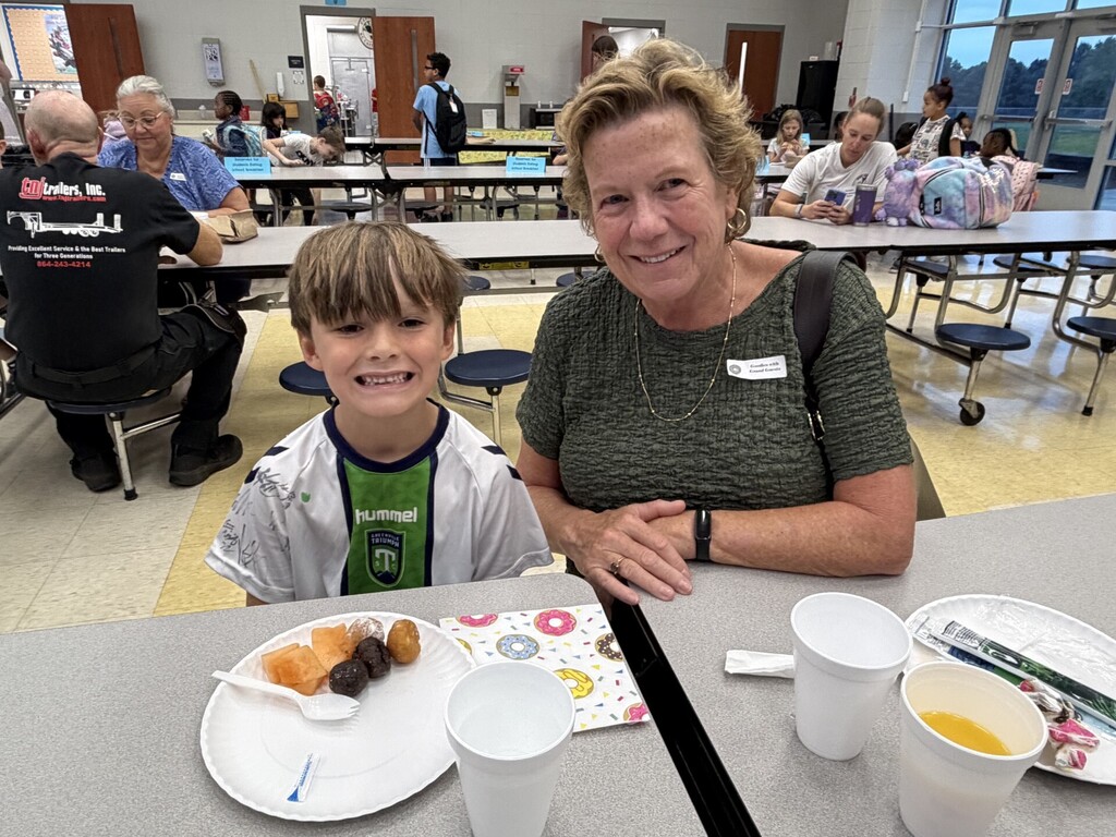 Student with grand guest eating in the cafeteria