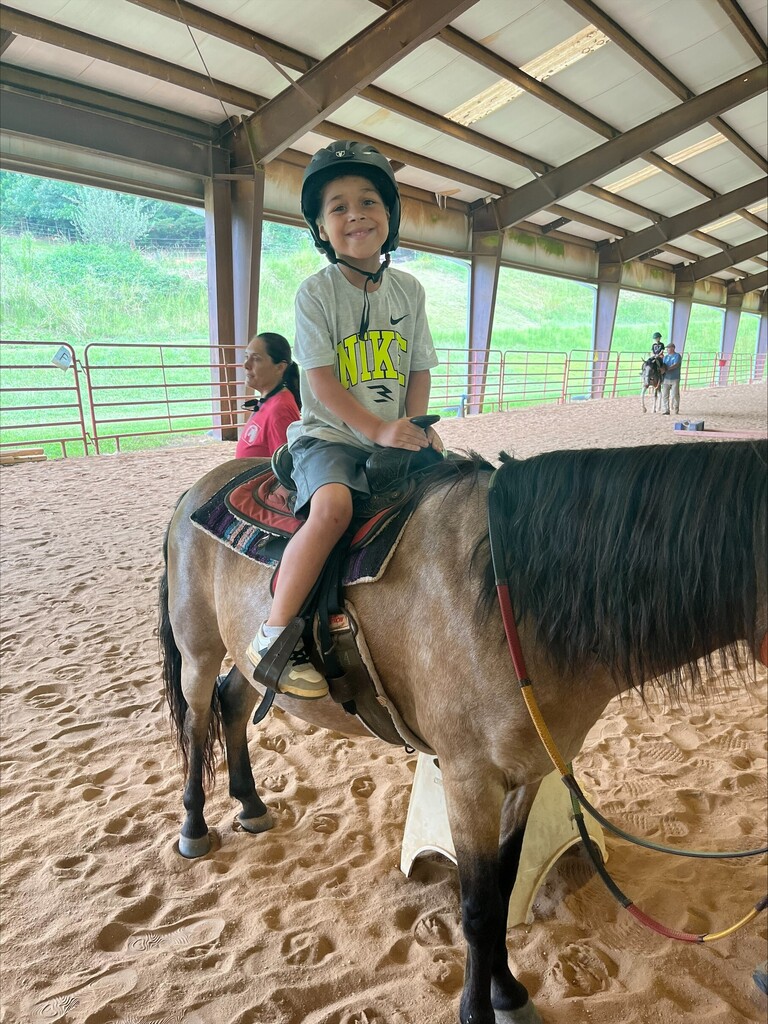 Student riding a horse at Happy Hooves