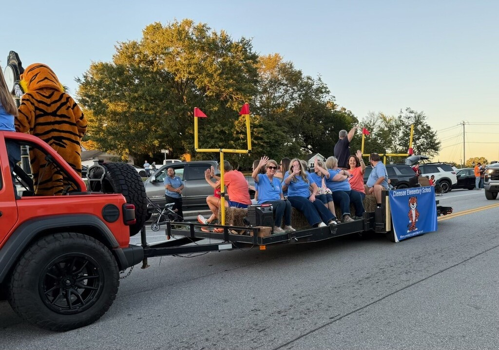 Teachers on the Clemson Elementary School float and as they wave and travel down the road in the parade.