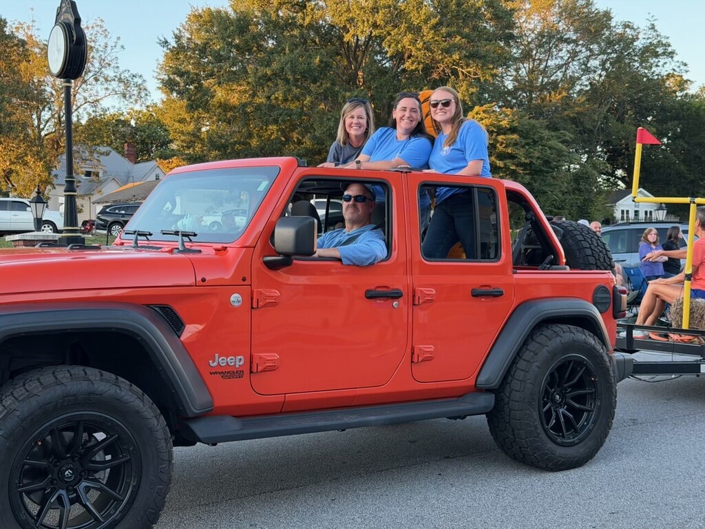 Assistant Principals in the back of the Jeep pulling the Clemson Elementary float.