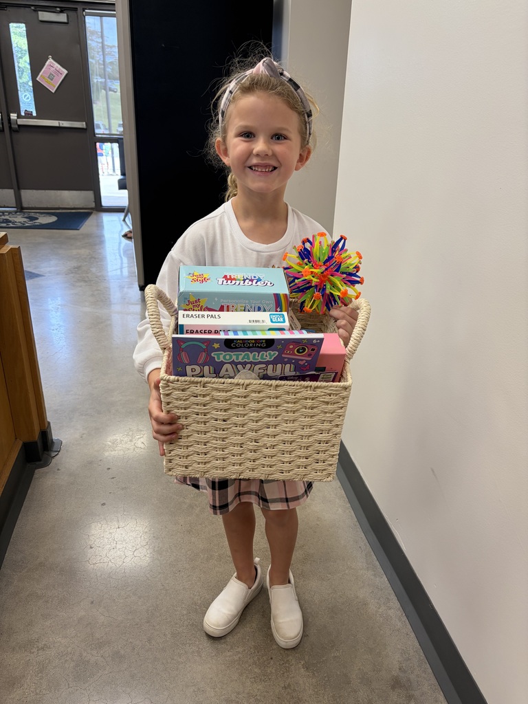 Student winner holding a basket full of fun goodies