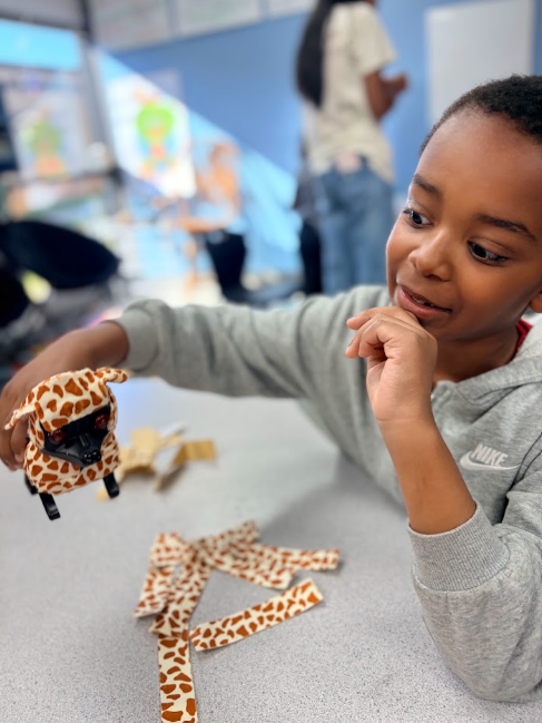 Student learning about the purpose of animal fur and covering his robotic dog with pretend fur