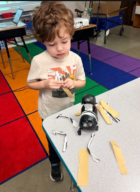 Student learning about the purpose of animal fur and covering his robotic dog with pretend fur