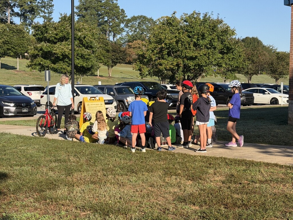 Fourth grade students listening to Mrs. Young share about bike maintence and adjusting the seat.