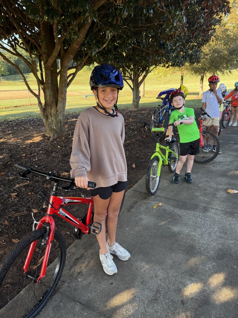 Fourth grade students standing with thier bikes waiting for instructions to ride.