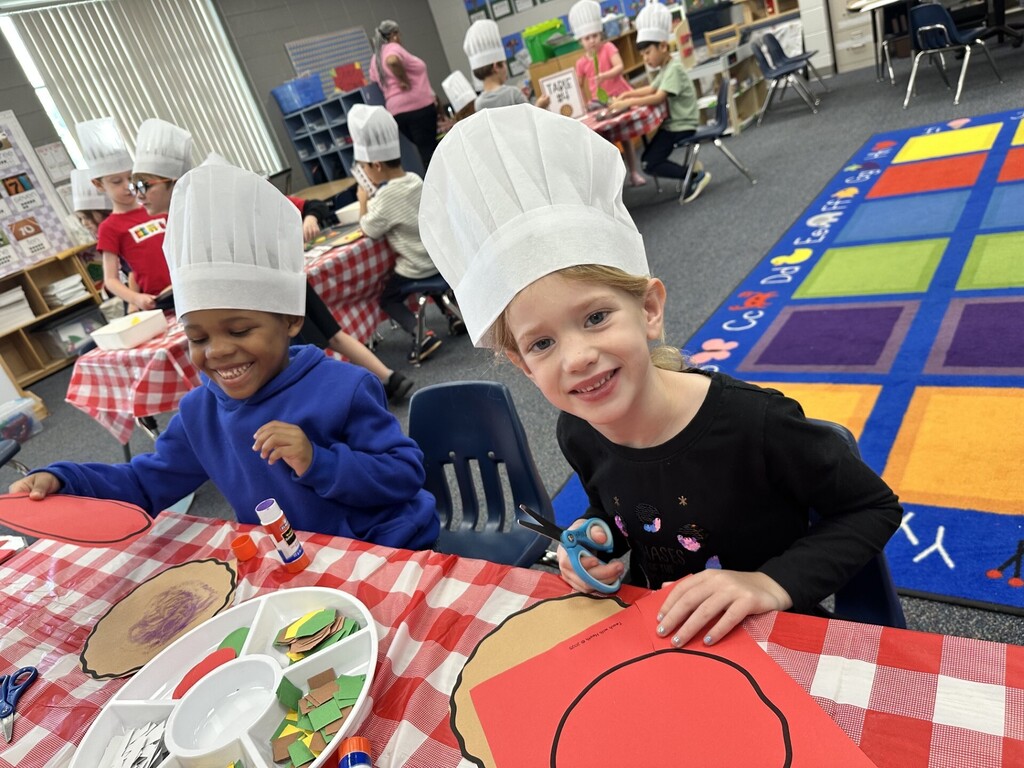 Cutting out shapes to make a pizza.