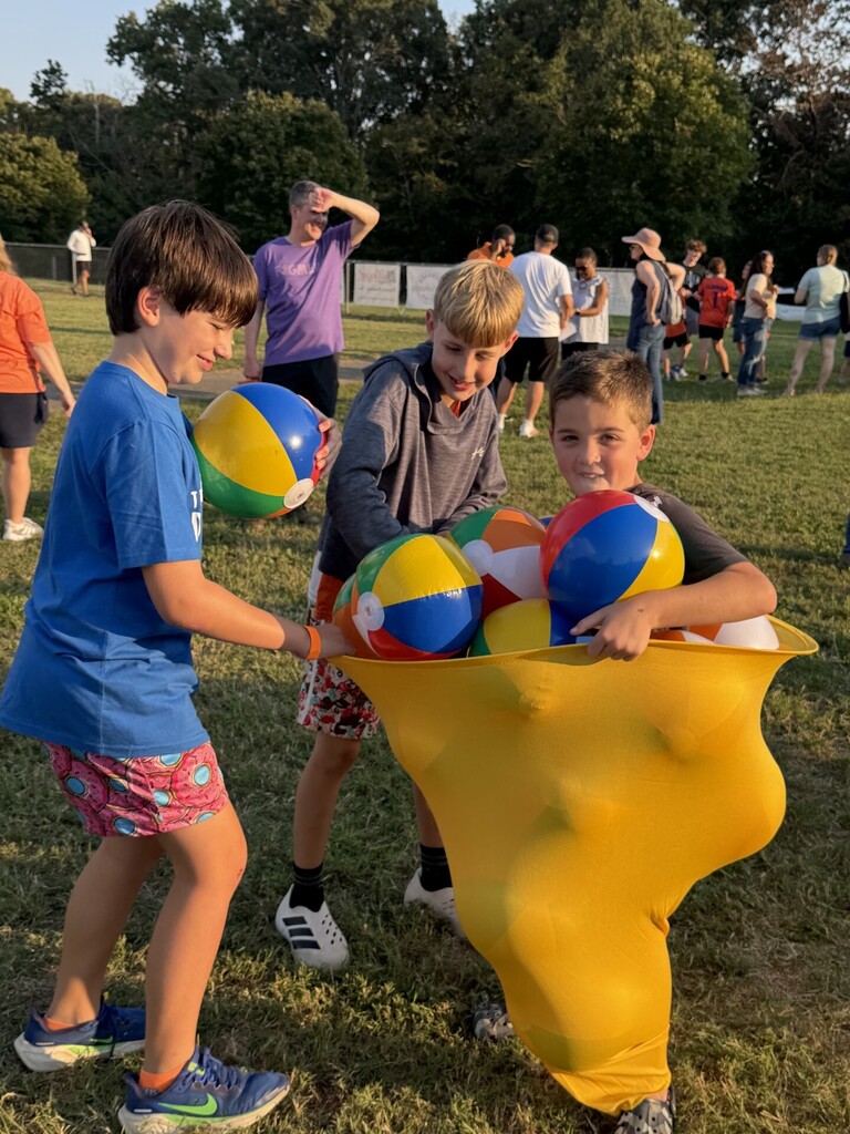 Fourth grade boys trying to put as many beach balls as they can into the pants.
