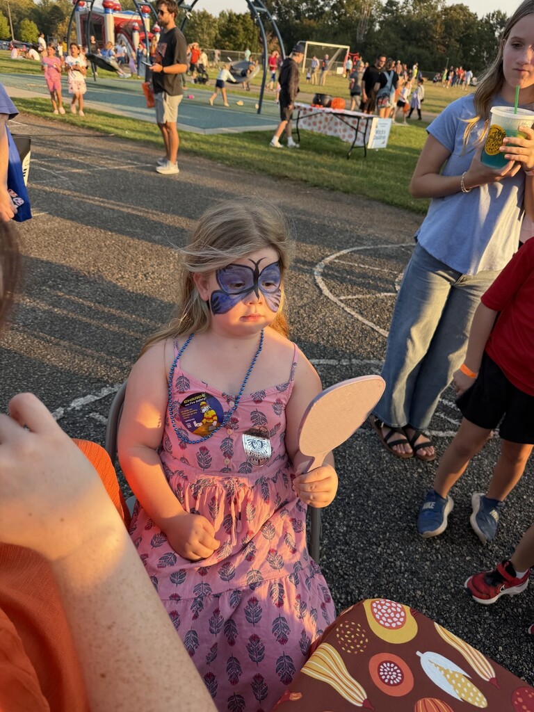 Student having a beautiful butterfly painted on her face.