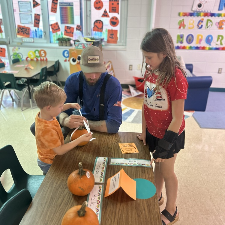 A family investigating the circumference of a pumpkin with ribbon
