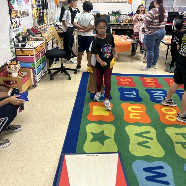 a student playing corn hole at family night 