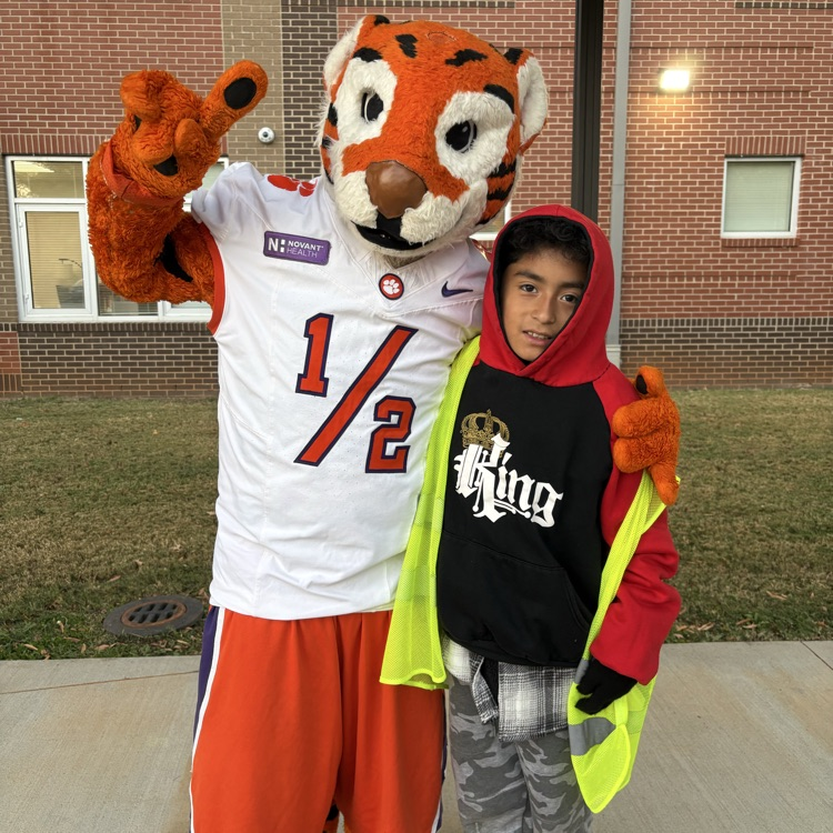 The Tiger Cub holding up the number 1 sign with one of our safety patrols