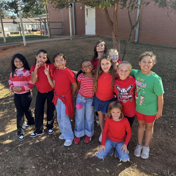 A group of third grade students showing off their red for red ribbon week
