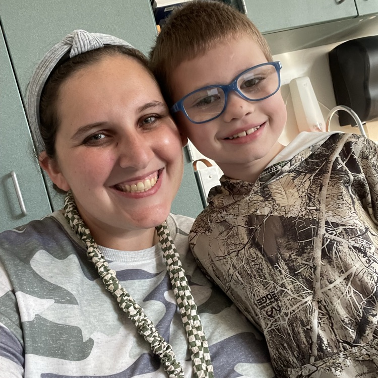 Ms. Quinones and a first grader posing in camo for red ribbon week