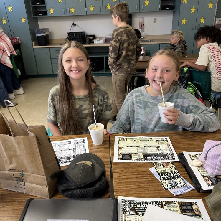 two smiling fifth grade girls drinking their dirty sodas after successfully completing the tasks. 