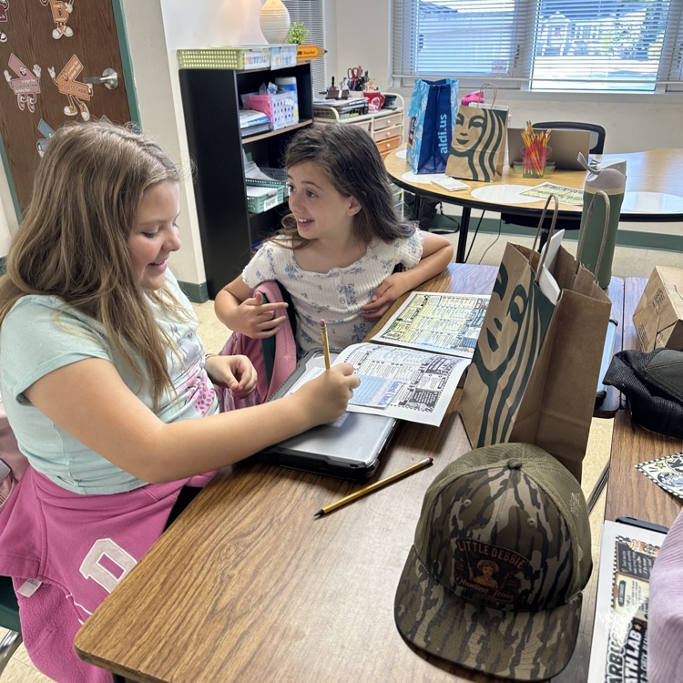 two fifth grade girls smiling while working on the tasks for dirty sodas