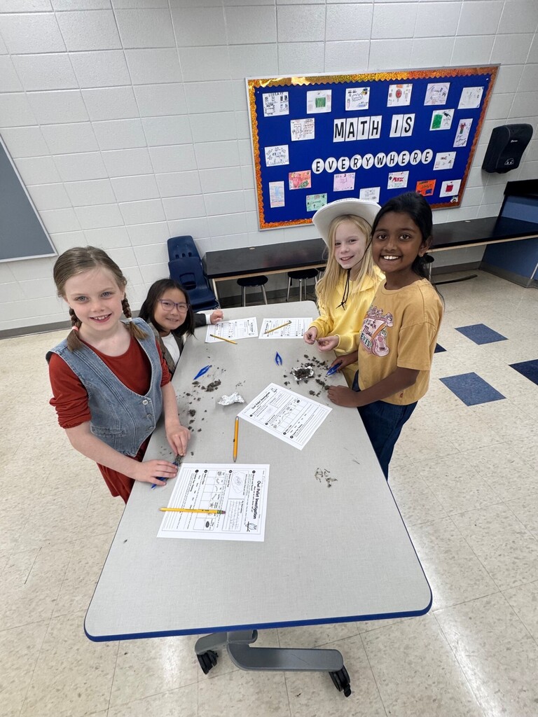 Third greade students in the science lab working on disecting owl pellets.