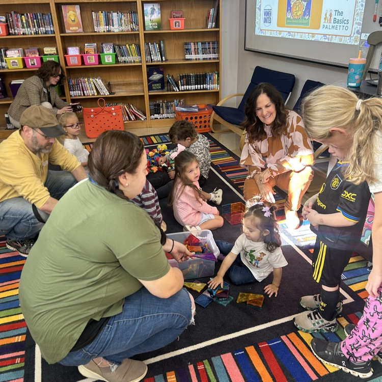 A parent and child play with blocks during pup 