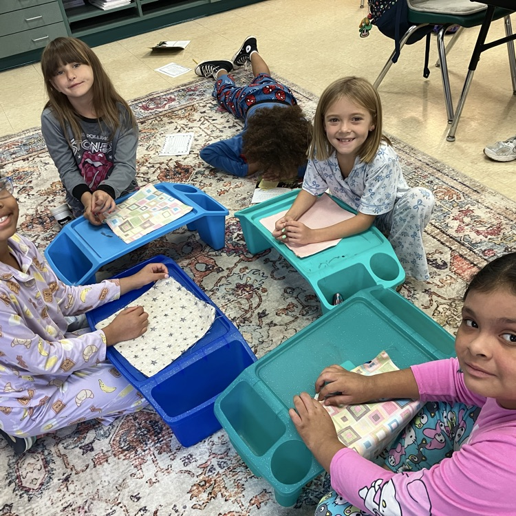 students dressed in pjs for read ribbon week are sewing pillows to go with their text