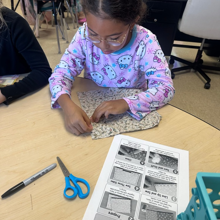 students dressed in pjs for read ribbon week are sewing pillows to go with their text