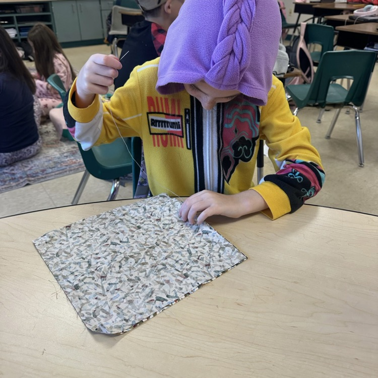 students dressed in pjs for read ribbon week are sewing pillows to go with their text