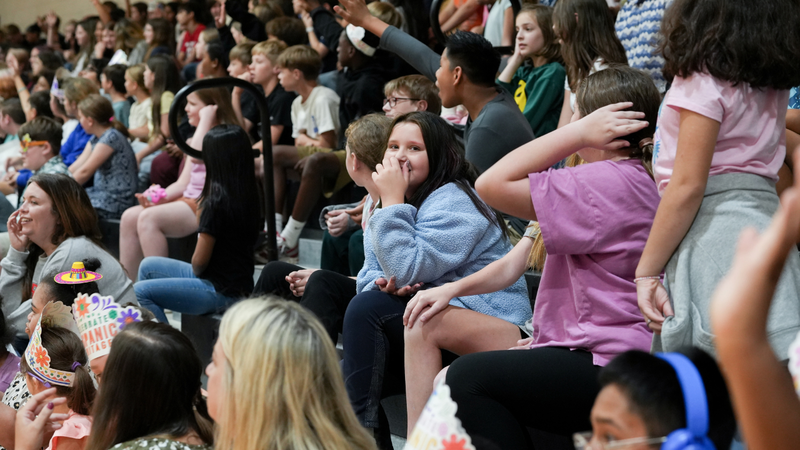 Student laughing in bleachers at assembly
