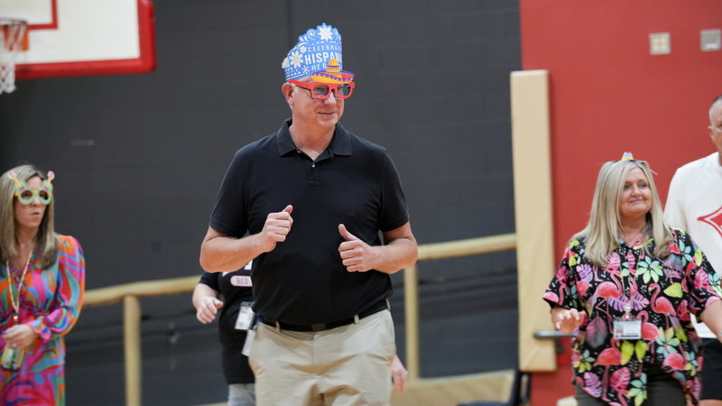 Teacher learning how to salsa at Hispanic Heritage assembly