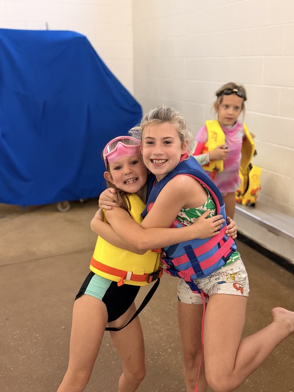 Second grade students in a life jacket at swimming lessons