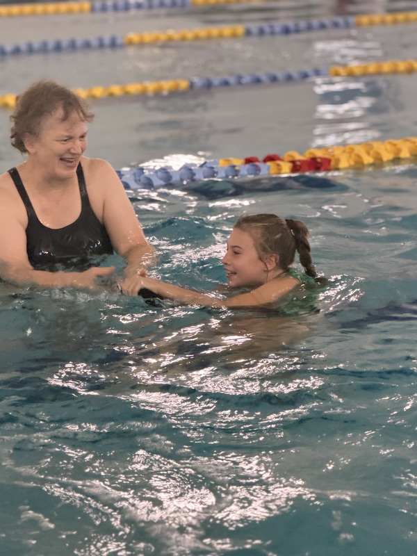 student swimming across the pool with an instructor