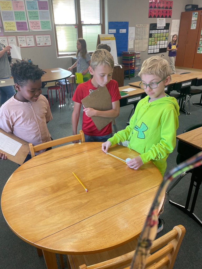 three students measuring pencils