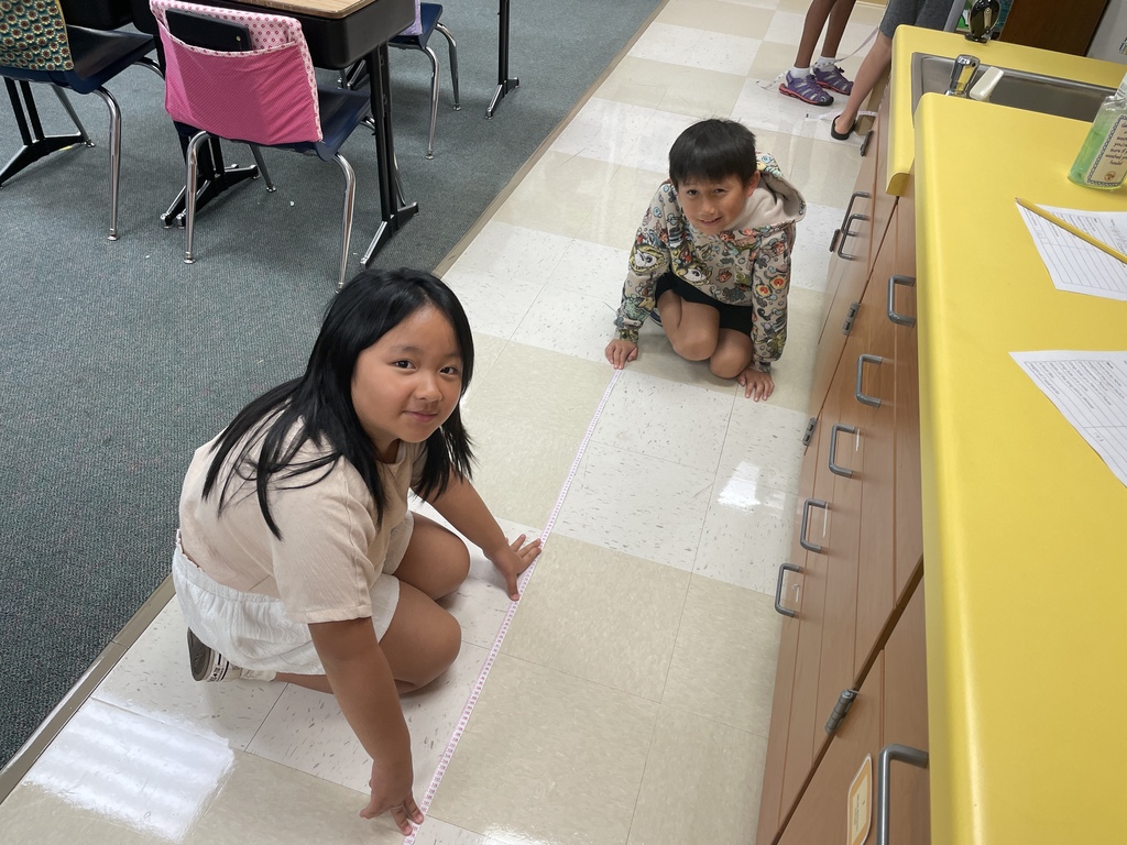 two students measuring tiles