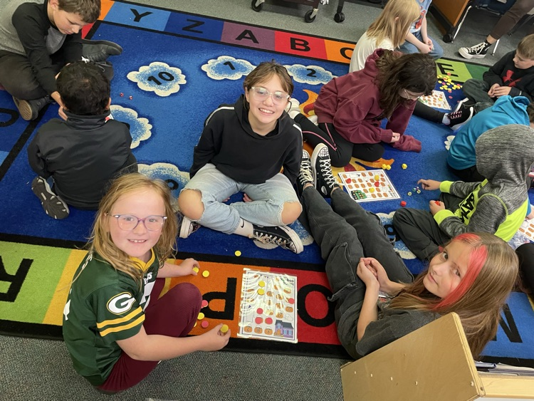 first and fifth grade girls playing a math game. 