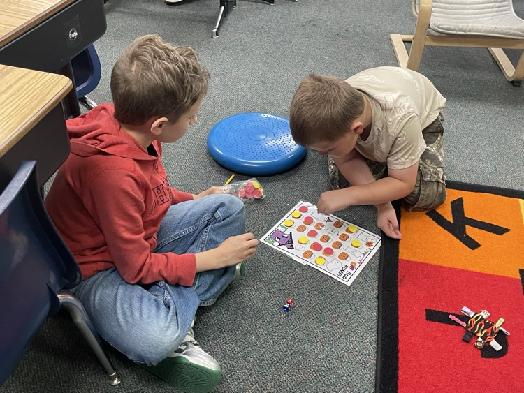 first and fifth grade boys playing a math game. 