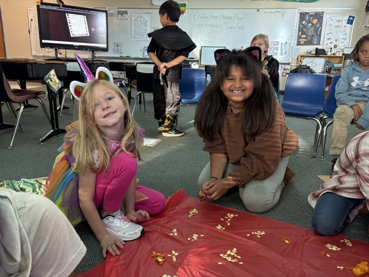 two 1st grade girls counting pumpkin seeds
