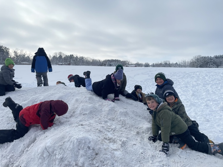 1st graders climbing on a snow hill.