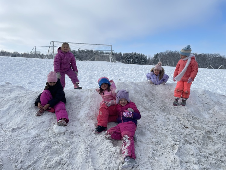 1st graders climbing on a snow hill.