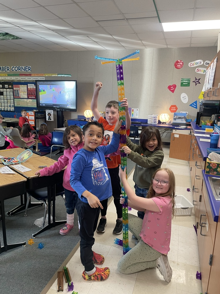 students working together to build a tower taller than them. 