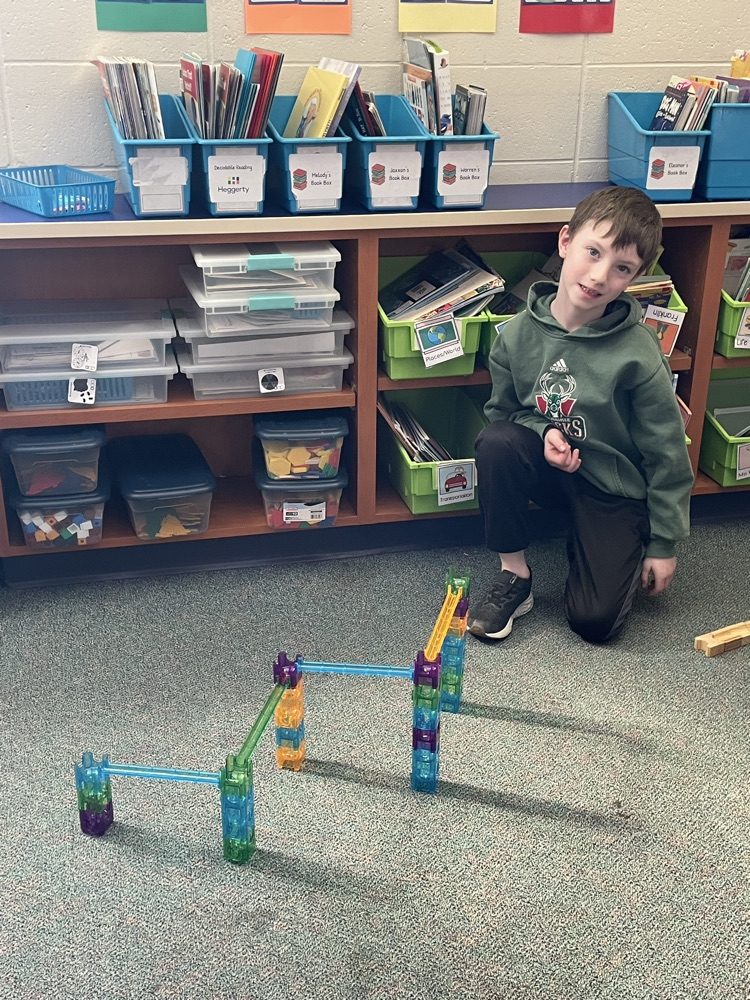 One first grade boy building a marble run