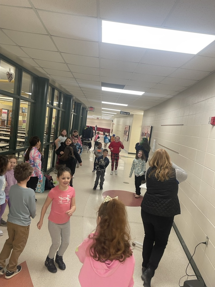 Children and principal dancing in the hallway