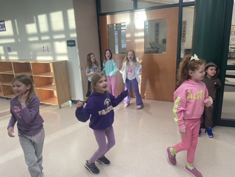 Children and principal dancing in the hallway