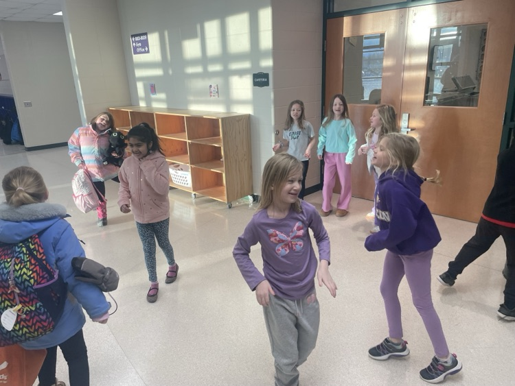 Children and principal dancing in the hallway