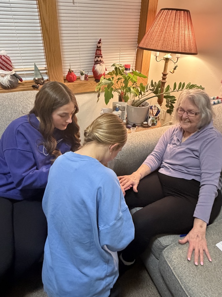 Key Club painting the nails of an elderly resident.