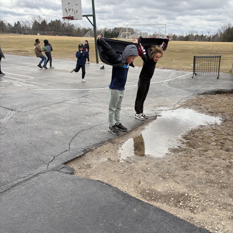 child outside pretending to fly with their coat