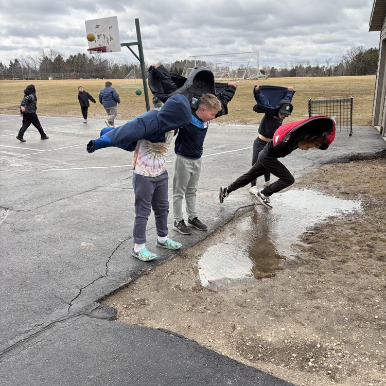 child outside pretending to fly with their coat