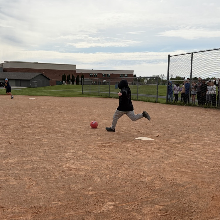 student kicking kickball