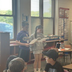 students reading to class of students