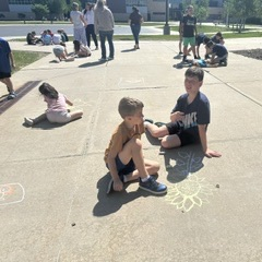 students using chalk on the sidewalk
