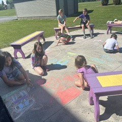 students using chalk on the sidewalk
