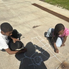 students using chalk on the sidewalk