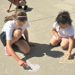 students using chalk on the sidewalk