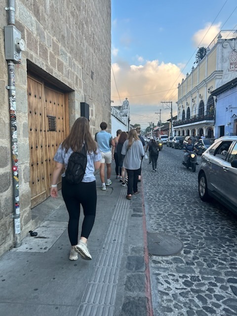 Mrs. Olig and SFHS students in Antigua, Guatemala walking down a cobblestone street.
